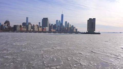 Lower Manhattan skyscraper stands beyond frozen Hudson River in New York City. Vidéo 300801153