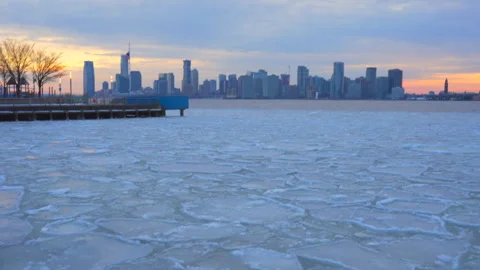 Lower Manhattan skyscraper stands beyond frozen Hudson River in New York City. Stock Footage 301234205