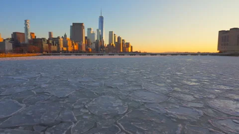 Lower Manhattan skyscraper stands beyond frozen Hudson River in New York City. Stock Footage 301331635