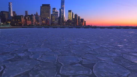 Lower Manhattan skyscraper stands beyond frozen Hudson River in New York City. Stock Footage 301417072