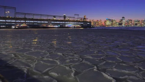 Lower Manhattan skyscraper stands beyond frozen Hudson River in New York City. 動画素材 301486848