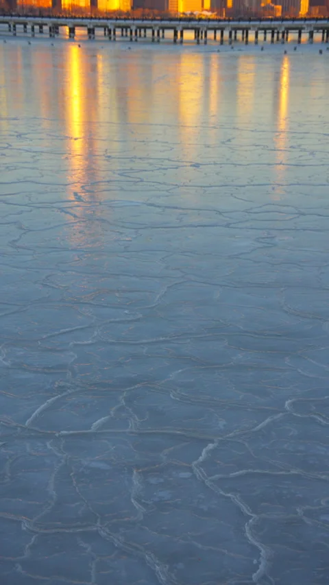 Lower Manhattan skyscraper stands beyond frozen Hudson River in dusk. Vídeo Stock 336640870