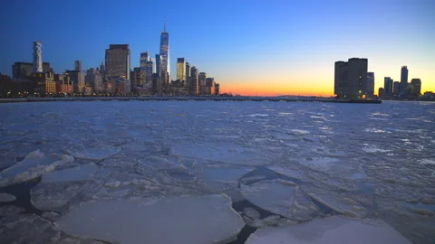 Lower Manhattan skyscraper stands beyond frozen Hudson River during twilight Vídeo Stock 336713551