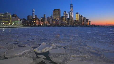 Lower Manhattan skyscraper stands beyond frozen Hudson River during twilight Vídeo Stock 336717196