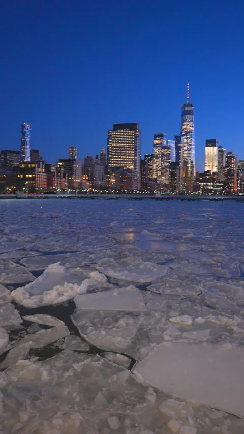 Lower Manhattan skyscraper stands beyond frozen Hudson River during twilight Vídeo Stock 336718164