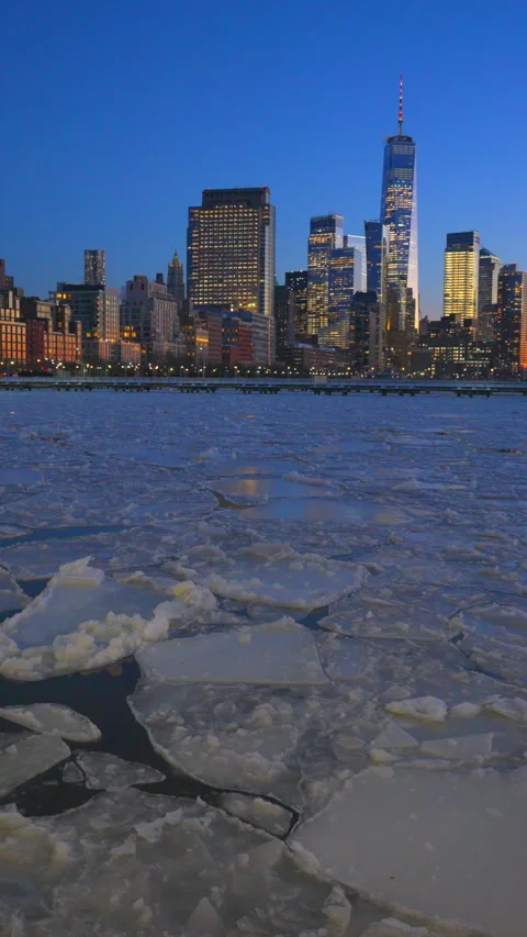 Lower Manhattan skyscraper stands beyond frozen Hudson River during twilight Vídeos de archivo 336719440