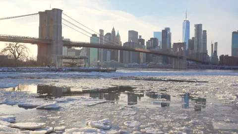 Lower Manhattan skyscraper stands beyond  frozen Pebble Beach in Brooklyn in NYC Vídeo Stock 336975472