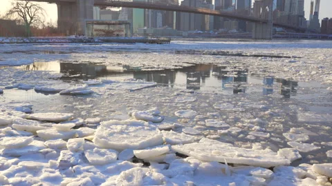 Lower Manhattan skyscraper stands beyond  frozen Pebble Beach in Brooklyn in NYC Vídeo Stock 336975716