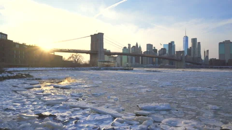 Lower Manhattan skyscraper stands beyond  frozen Pebble Beach in Brooklyn in NYC Vídeos de archivo 336979420