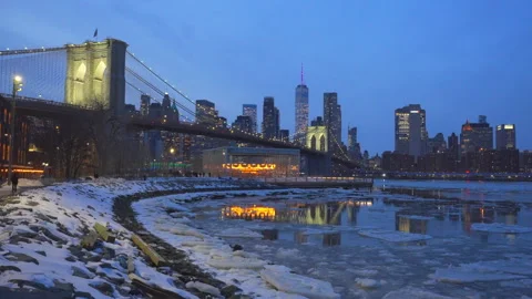 Lower Manhattan skyscraper stands beyond  frozen Pebble Beach in Brooklyn in NYC Vídeo Stock 337006519