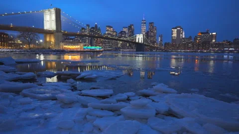 Lower Manhattan skyscraper stands beyond  frozen Pebble Beach in Brooklyn in NYC Vídeo Stock 337007650