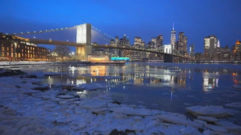 Lower Manhattan skyscraper stands beyond  frozen Pebble Beach in Brooklyn in NYC Vídeos de archivo 337008384
