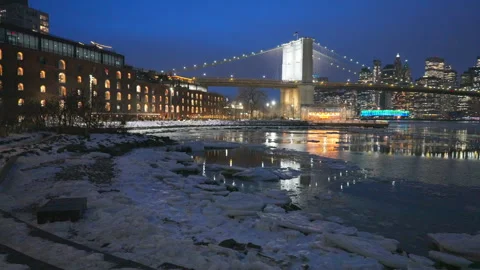 Lower Manhattan skyscraper stands beyond  frozen Pebble Beach in Brooklyn in NYC Vídeos de archivo 337008962