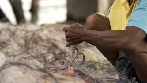 A lower mid shot of man taking crabs out of fishing net 스톡 동영상 115675361