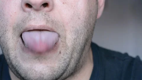 Lower part of the face of a middle-aged man. eats and licks his lips. close up s Видео 256321901