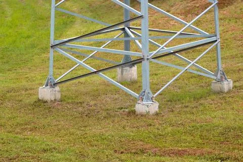 Lower part of a large electric support on a background of green grass Stock Photos