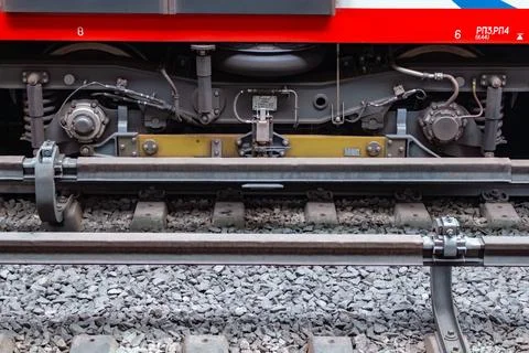 Lower part of a modern passenger train carriage on railway tracks with ball Stock Photos