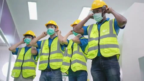 Lower shot of factory workers man and woman or technician or engineer wear mask Stock Footage 147453974