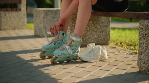 Lower View of Individual Adjusting Roller Skate with Sneaker Nearby on Sunlit Video stock 295172093