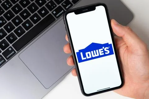Lowes the application is open in the smartphone. The man is holding a mobile Stock Photos