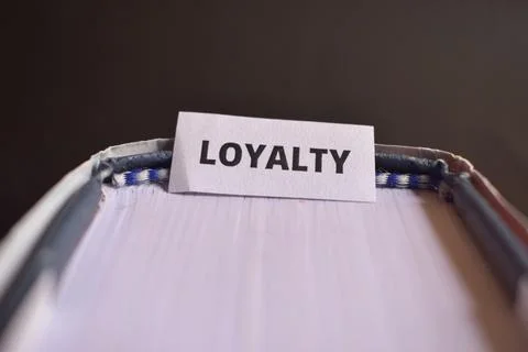 Loyalty Paper Tab Between Book Pages Symbolizing Faithfulness, Dedication a.. Stock Photos