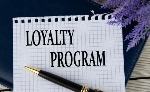 LOYALTY PROGRAM - words on a white sheet with a black notepad and pen Stock Photos