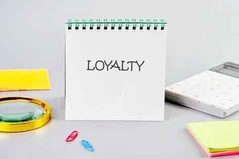 LOYALTY word written in a notebook in a composition with a calculator, a Stock Photos