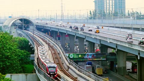 LRT Jabodebek passes alongside Sheikh Mohamed Bin Zayed toll road Stock Footage 330566722