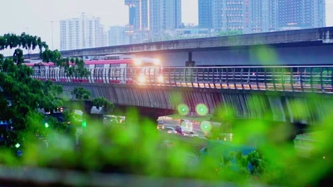 LRT Jabodebek passes through the track during rainy day Stock Footage 330566463
