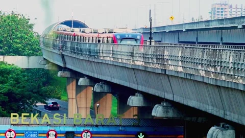 LRT Jabodebek passes through the track Stock Footage 330566721