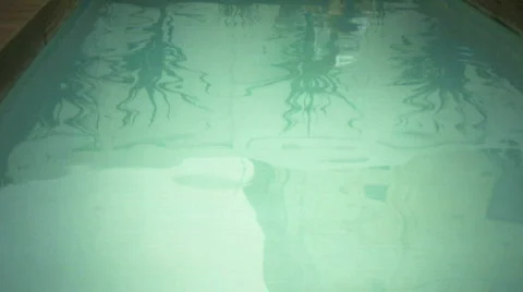 LS PAN OF A MAN WORKING ON A LAPTOP AND THEN DIPPING HIS FEET IN A SWIMMING POOL 스톡 동영상 543506
