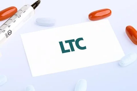LTC Long Term Care text written on a white business card lying on a light bac Stock Photos