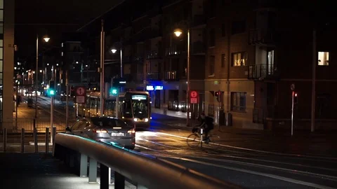 Luas light rail train passes through Spencer Dock, Dublin, Ireland at night Stock Footage 102581308