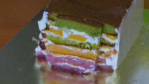 Lubricate the biscuit cake with multi-colored cake layers with butter cream Video stock 108558359