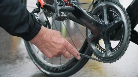 Lubricating a chain on a bicycle, applying salidol to a bicycle chain with a Stock Footage 261895514