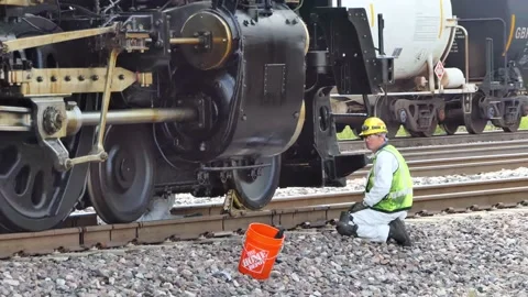 Lubrication crewman working under Big Boy 4014 locomotive with his buddy nearby Vídeo Stock 159264250
