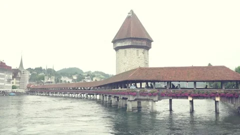 A lucerne bridge over a river with a large building in the background Stock Footage 313351052