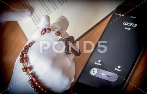 Lucifer calling a woman praying with a rosary Stock Photos