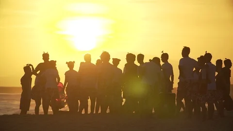 Lucky crowd on a seeshore looking at a huge sun in Vietnam at sunset in slo-mo Stock Footage 100801050