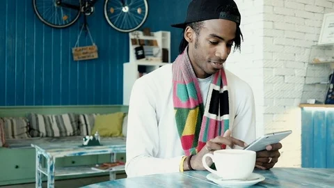 Lucky handsome man working on a tablet, looking at camera and smiling. Video stock 75892479