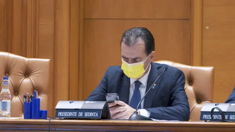 Ludovic Orban, with face mask, using the phone in Parliament's Session. Stock Footage 158184019