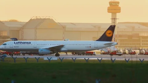 Lufthansa airplane passing by Lufthansa Technik building in Fuhlsbuettel airport Stock Footage 71061416