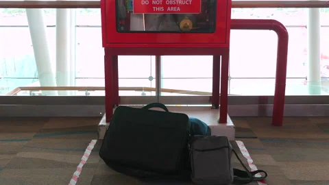 Luggage and personal items placed near warning sign at airport Stock Footage 285073535