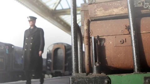 Luggage trolley on steamy platform with train and inspector in background 動画素材 74144791