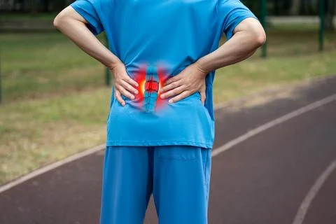 Lumbar intervertebral spine hernia, man with back pain on a running track aft Photos