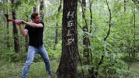 Lumberjack with axe chopping a tree, on the trunk and the words: Help Stock Footage 111310679