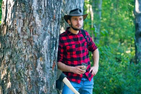 Lumberjack with axe on forest background. Man doing mans job. A handsome young Stock Photos