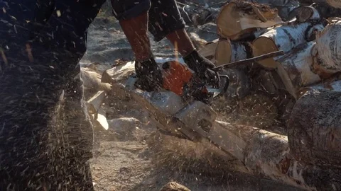 Lumberjack chopping wood with chainsaw and axe in slow motion Stock Footage
