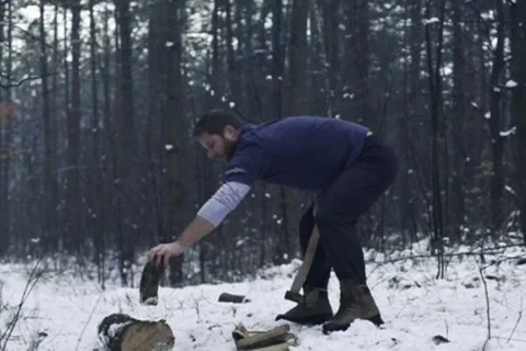 Lumberjack chopping wood in the winter, slow motion NTSC Stock Footage