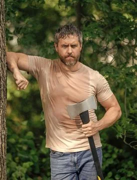 Lumberjack Hispanic man in forest with axe. Lumberjack carries axe. Sweating man Stock Photos